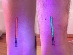 two people with matching tattoos on their legs, one has a pencil and the other has an arrow