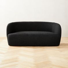 a black couch sitting on top of a wooden floor