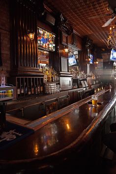 a dimly lit bar with lots of tvs on the wall