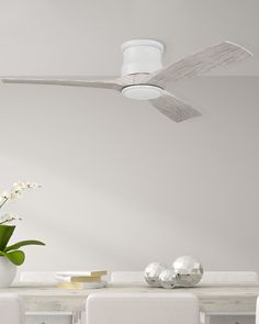 a white dining room table with chairs and a ceiling fan