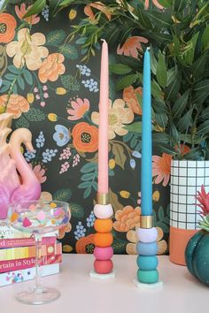 colorful candles are sitting on a table next to books