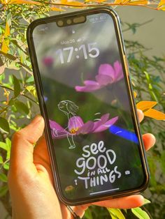 someone is holding up their phone with the message see good things on it in front of some flowers