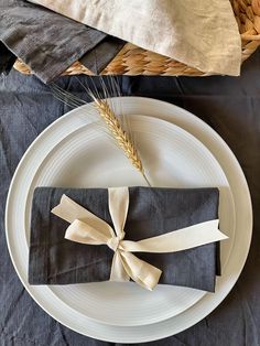 a place setting with napkins and wheat stalks on the plate, ready to be served