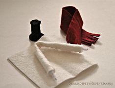 an origami bird sitting on top of a piece of white paper next to a red and black object