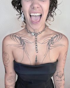 a woman with tattoos on her chest making a funny face