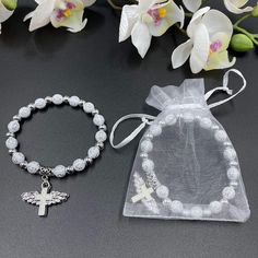 "These Wing of Angel bracelets are absolutely stunning Favors for baptism. 12 Pcs WHITE ANGEL CHARM BRACELET - A meaningful and useful favor for Baptism and religious events The Wings of angel adorn with beautiful enamel cross Stretchy bracelet fits youth and adult wrists. Organza bags included. Wood bead size 8mm, Charm size: .75\" x 1\", fits youth & adult" White Adjustable Bracelet For Confirmation, Adjustable White Bracelet For Confirmation, Adjustable White Rosary Bracelet For Confirmation, Communion Party Favors, Baptism Party Favors, First Communion Party, Angel Bracelet, Enamel Cross, Christening Favors