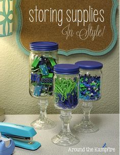 three glass jars filled with blue and green items on top of a counter next to a sign that says storing supplies in style