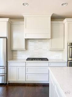 a kitchen with white cabinets and stainless steel appliances