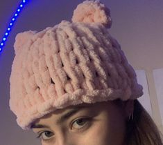 a woman wearing a pink knitted hat with ears