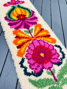 a white rug with colorful flowers on it