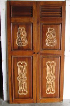 two wooden doors with carved designs on them