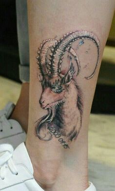 a tattoo on the leg of a person with a goat head and long horn horns