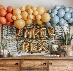 there are balloons that spell out the word party next to a dresser with plants on it