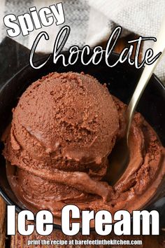 a bowl filled with chocolate ice cream on top of a wooden table next to a spoon