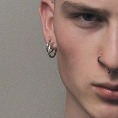 a young man with piercings on his nose and nose ring in front of him