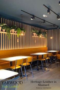 a restaurant with yellow chairs and plants on the wall