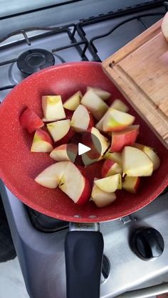 someone is cutting apples into small pieces in a red bowl on top of the stove