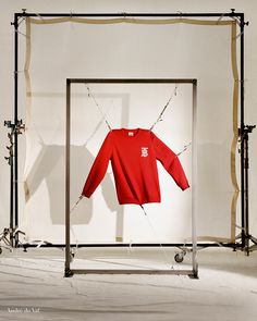 a red shirt is hanging on a clothes rack