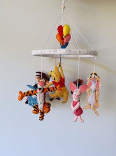 winnie the pooh and tigger mobiles hanging from a ceiling fixture in a child's room