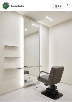 an office chair sitting in front of a large mirror and shelf with shelves on each side