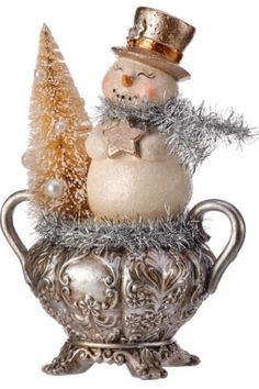 a snowman sitting on top of a silver cup