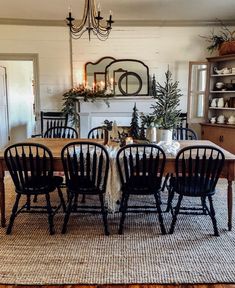 the dining room table is set with black chairs and place settings for four, along with a fireplace