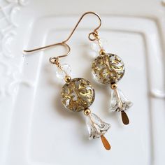 Round translucent beads are covered in gorgeous gold swirls. Above it you will find a clear faceted crystal and below is a beautiful clear tulip with a slight gold wash. These earrings have a lot of sparkle. They are on gold-filled ear wires. 2 inches in length  Lead and nickel free Elegant Cheap Czech Glass Earrings, Cat Necklace Silver, Hand Beaded Necklace, Gold Chain Earrings, Snowflake Necklace, Whimsical Jewelry, Romantic Jewelry, Earrings Ideas, Swirl Earrings