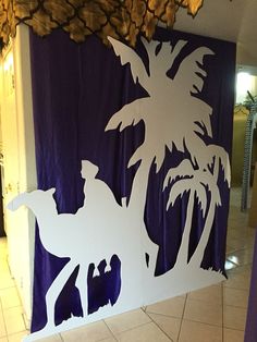 a cutout of a man riding a horse in front of a palm tree on a blue and white backdrop