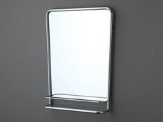 a bathroom mirror mounted on the wall above a towel rack in front of a gray wall