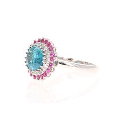 an oval blue topaz ring with pink and white stones in the center on a white background