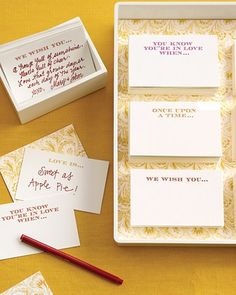 several cards and envelopes on a yellow table with a red pen next to them