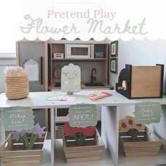 the pretend play flower market is set up with wooden crates and flowers in them for display