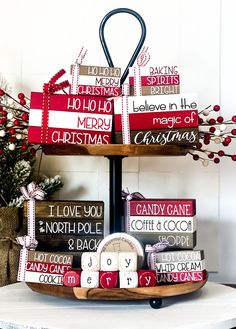 a three tiered tray with christmas signs on it, and a clock in the center