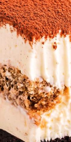 a close up of a cake with white frosting and brown crumbs on top