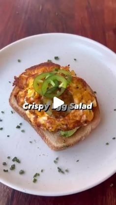 a white plate topped with a piece of bread covered in cheese and toppings on top of it