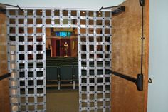 an open door with metal bars on each side and a television screen in the background