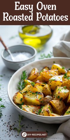 a white bowl filled with roasted potatoes on top of a table