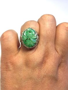 This is a natural coloured antique jade ring decorated with an intricate oriental pattern. The antique jade is over 100 years ago and with beautiful colour. With an adjustable band, this ring gives you the freedom to find your perfect fit.  There are Chinese words "壽" meaning "Longevity" on both sides of the ring.  This detailed filigree work with excellent Chinese craftsmanship makes this ring so stunning.  This Chinese patterns connect the sterling silver band to give it an elegant feel.  This Traditional Green Oval Emerald Ring, Oval Carved Filigree Ring For Anniversary, Traditional Green Hallmarked Rings, Vintage Carved Green Ring, Engraved Green Emerald Ring, Vintage Green Carved Ring, Traditional Green Sterling Silver Rings, Green Carved Rings For Anniversary, Antique Green Emerald Ring With Intricate Design