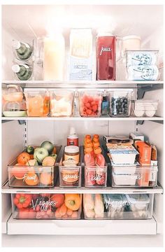 an open refrigerator filled with lots of different types of fruit and juice in plastic containers