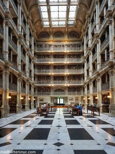 the inside of a large building with many tables and chairs in front of it on a checkerboard floor