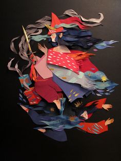 an assortment of colorful paper cut outs sitting on top of a black surface with scissors