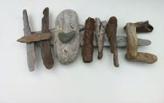 driftwood letters are arranged in the shape of hearts and arrows on a white background