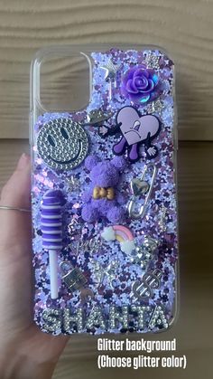 someone is holding up their phone case with some stuff on it and the back cover has purple sequins