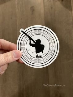 a person holding up a sticker with the image of a baseball player