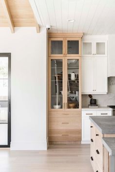 a kitchen with white cabinets and wood floors