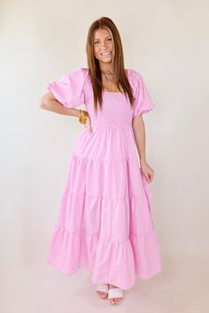 Make a statement in the Santorini Sunshine Short Balloon Sleeve Maxi Dress. This beautiful light pink dress features a smocked bodice with short balloon sleeves and a tiered skirt for a timeless look. Exuding effortless elegance, this dress is perfect for any special occasion. Arté is wearing a size small. Size Measurements: Small: 2-6 | Bust: 15 inches across the front (smocked, stretches) | Length: 50 inches Medium: 8-10 | Bust: 16 inches across the front (smocked, stretches) | Length: 51 inch