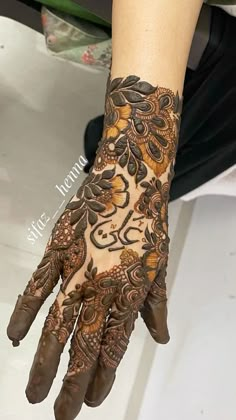 a woman's hand with henna tattoos on it