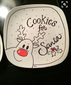 two plates with christmas designs on them sitting next to each other in front of a black table