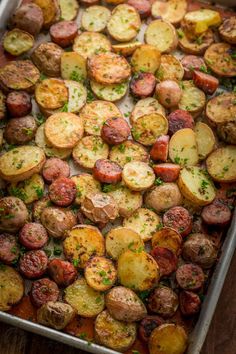 roasted potatoes with herbs and parsley on a baking sheet