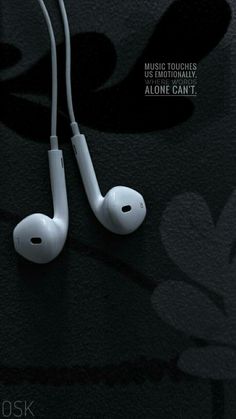 the ear buds are connected to each other on a black surface with an advertisement in the background